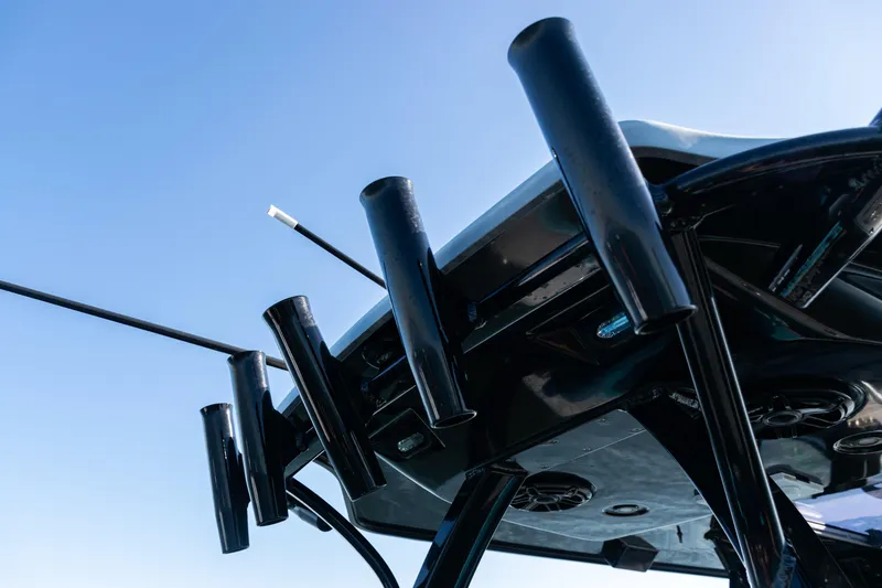 Slide: The Image of 2022 Costa Custom Boats 264, rod holders on sleek black structure against blue sky. - 36