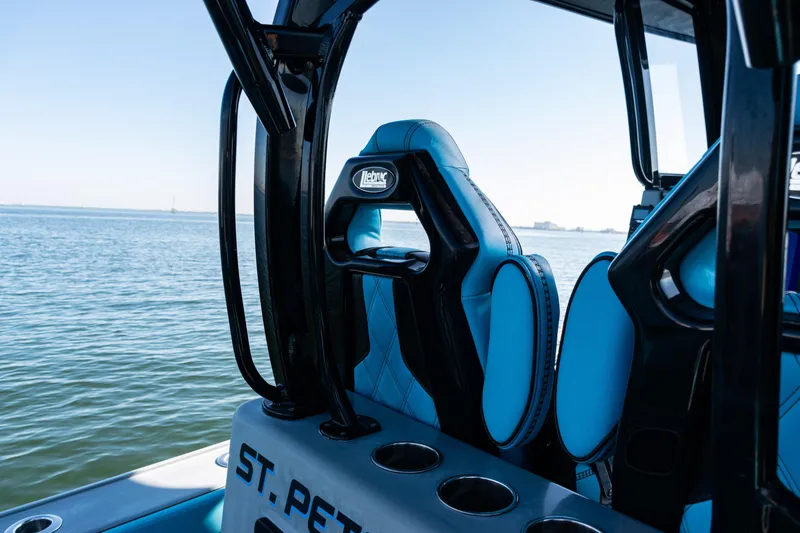 Slide: The Image of 2022 Costa Custom Boats 264 interior with blue seating, overlooking calm waters. - 37