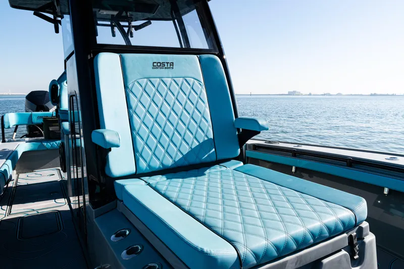 Slide: The Image of 2022 Costa Custom Boats 264 with luxurious blue seating on a calm sea. - 39
