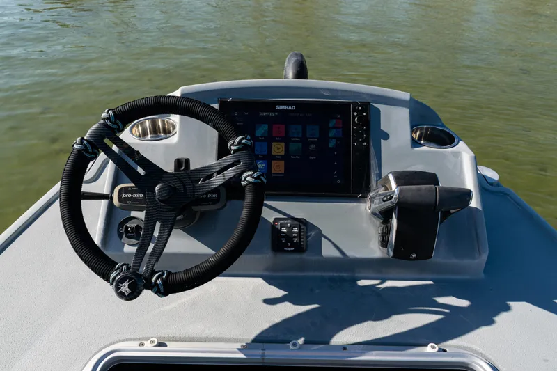 Slide: The Image of 2022 Costa Custom Boats 264 helm with steering wheel and navigation display. - 42