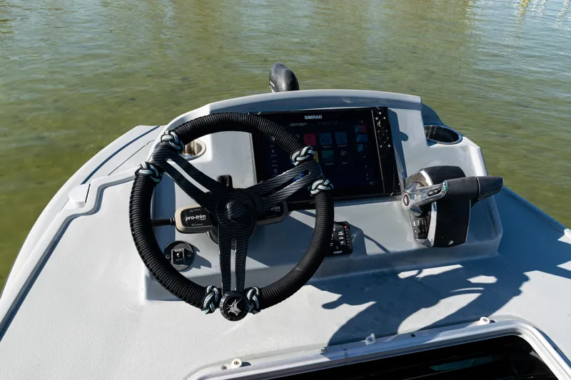 Slide: The Image of 2022 Costa Custom Boats 264 helm with steering wheel and navigation display. - 44