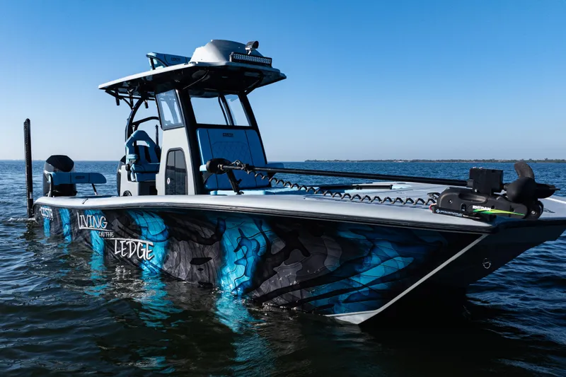 Slide: The Image of 2022 Costa Custom Boats 264 with vibrant blue design on calm water. - 50