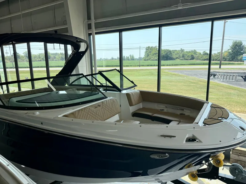 Slide: The Image of A 2026 Sea Ray SDX 230 boat is displayed in a showroom with large windows. - 13