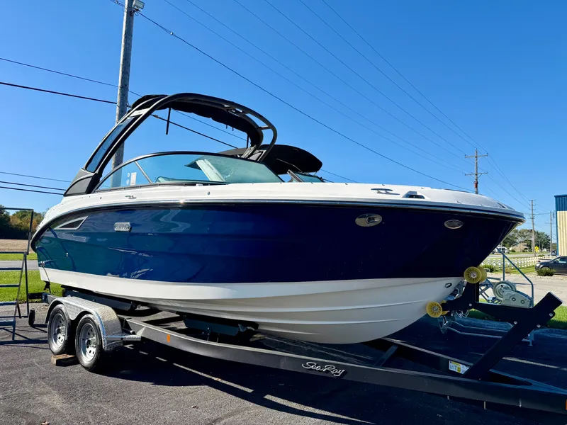 The Image of A 2026 Sea Ray SDX 230 on a trailer, featuring a blue hull and black canopy. - 0