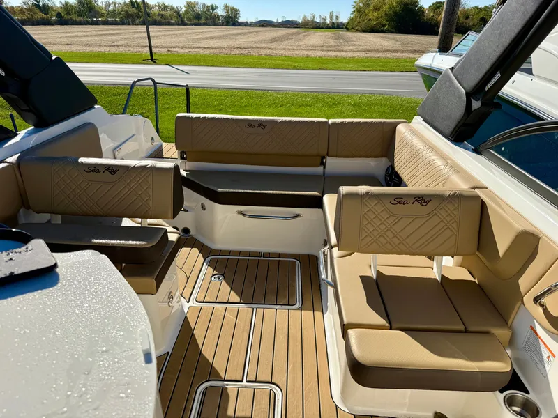 Slide: The Image of The image shows the cockpit of a Sea Ray SDX 230 boat with beige upholstery and wood flooring. - 8