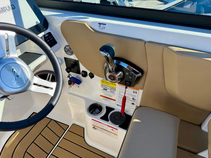 Slide: The Image of The image shows the cockpit of a Sea Ray SDX 230 with controls and cup holders. - 11