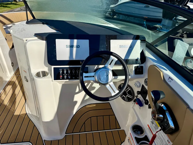 Slide: The Image of The image shows the cockpit of a Sea Ray SDX 230 boat with modern instruments. - 10