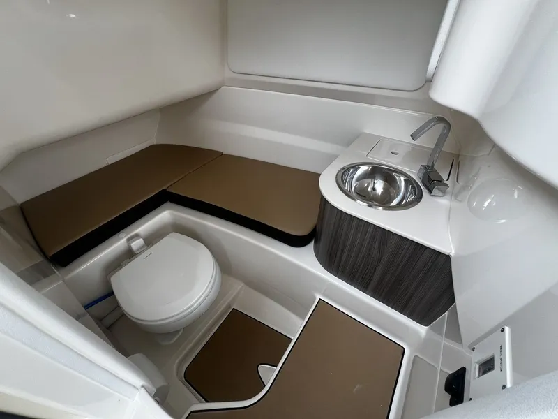 Slide: The Image of The image shows the bathroom of a 2026 Sea Ray SDX 250 with a toilet and sink. - 17