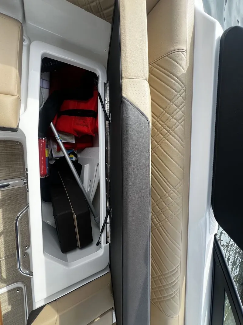 Slide: The Image of An open storage compartment on a Sea Ray SDX 250 boat with various items inside. - 20