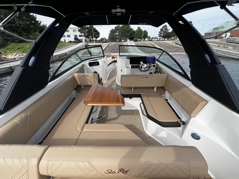Slide: The Image of Sea Ray SDX 250 2026: Spacious cockpit with beige upholstery and modern helm station. - 6