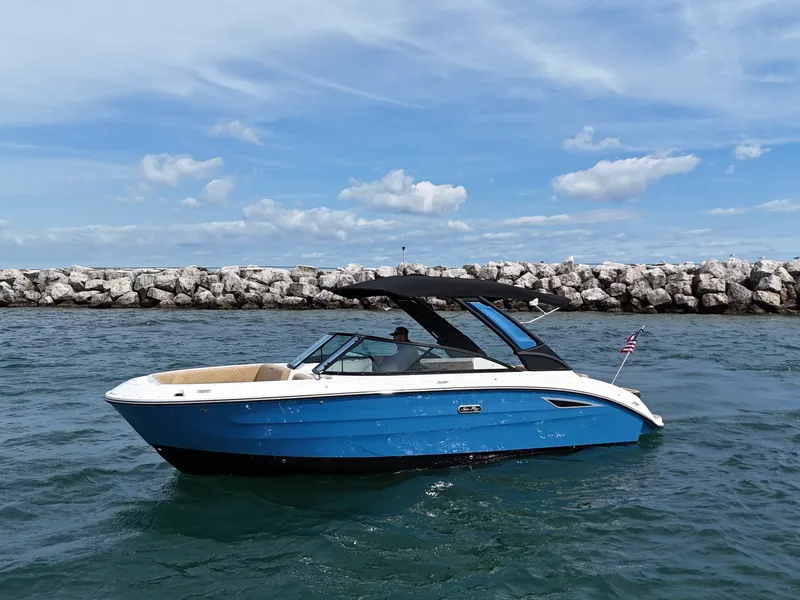 The Image of 2026 Sea Ray SDX 250 on the water with a blue hull and black canopy. - 0