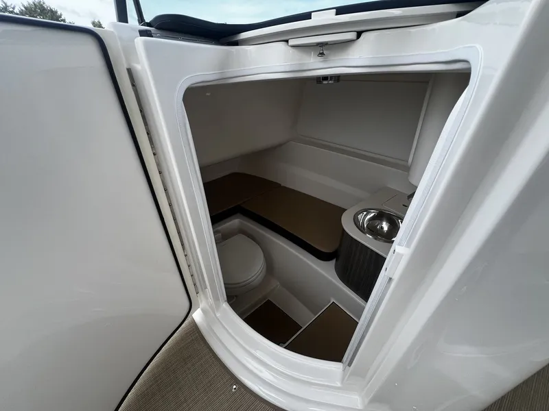 Slide: The Image of Interior view of a 2026 Sea Ray SDX 250 featuring a toilet and sink. - 16