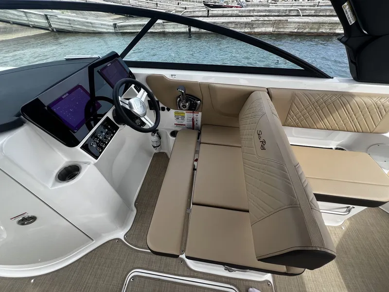 Slide: The Image of The image shows the cockpit of a 2026 Sea Ray SDX 250 with modern instruments and beige seating. - 10