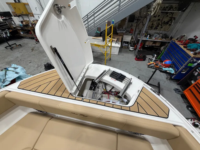 Slide: The Image of 2026 Sea Ray SDX 270 boat with open storage hatch in workshop. - 46