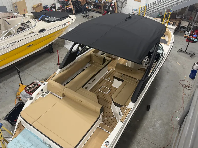 Slide: The Image of 2026 Sea Ray SDX 270 boat in workshop with black canopy. - 8