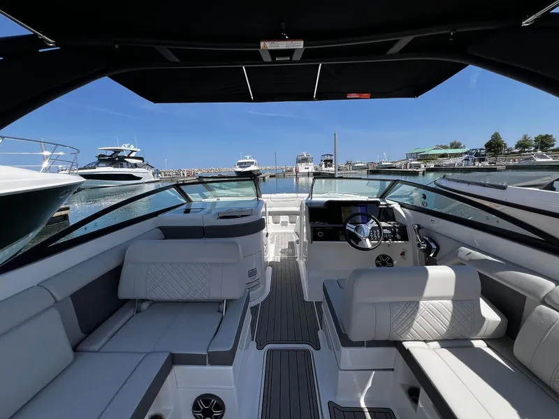 Slide: The Image of 2026 Sea Ray SDX 290 with a luxurious cockpit and modern seating at the marina. - 18