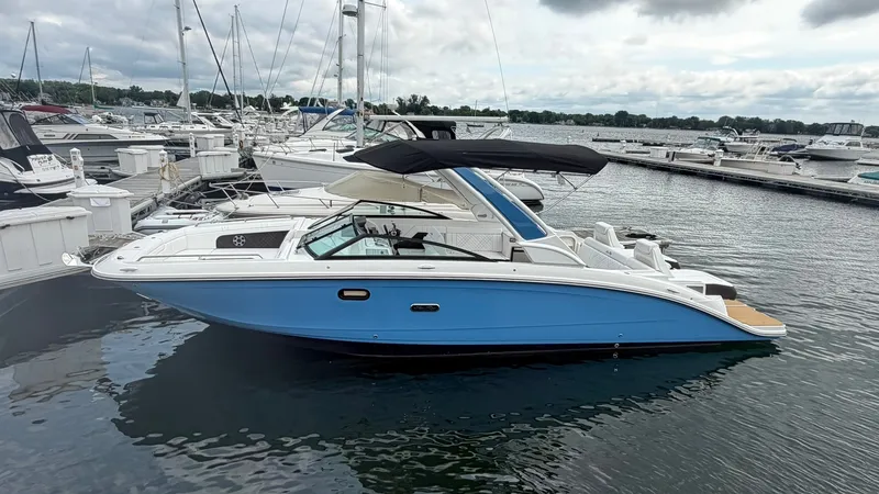 The Image of A 2026 Sea Ray SDX 290 is docked in the water, surrounded by other boats in the marina. - 0