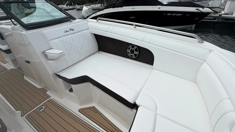 Slide: The Image of The image shows the cockpit of a 2026 Sea Ray SDX 290 with white upholstery and wood flooring. - 31