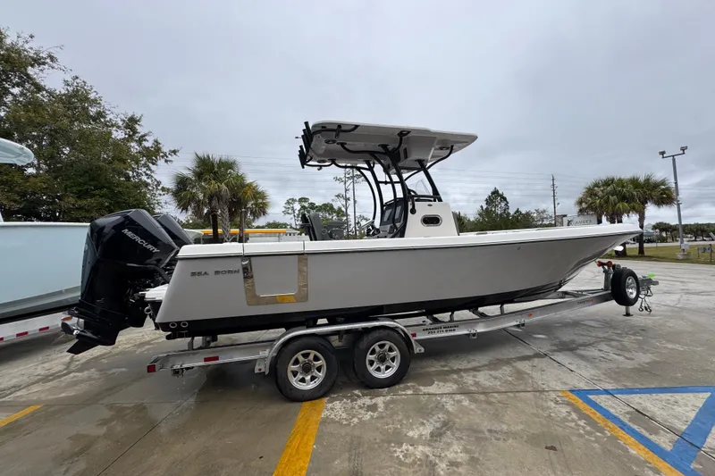 Slide: The Image of 2026 Sea Born LX26 Center Console boat on trailer, parked outdoors. - 10
