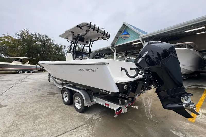 Slide: The Image of 2026 Sea Born LX26 Center Console boat on trailer, featuring Mercury outboard engine. - 15