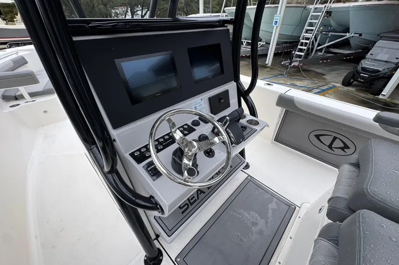 Slide: The Image of 2026 Sea Born LX26 Center Console boat interior with steering wheel and dual screens. - 29