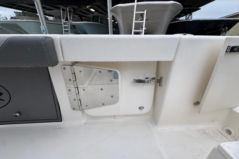Slide: The Image of 2026 Sea Born LX26 Center Console boat interior with storage compartment and latch detail. - 36
