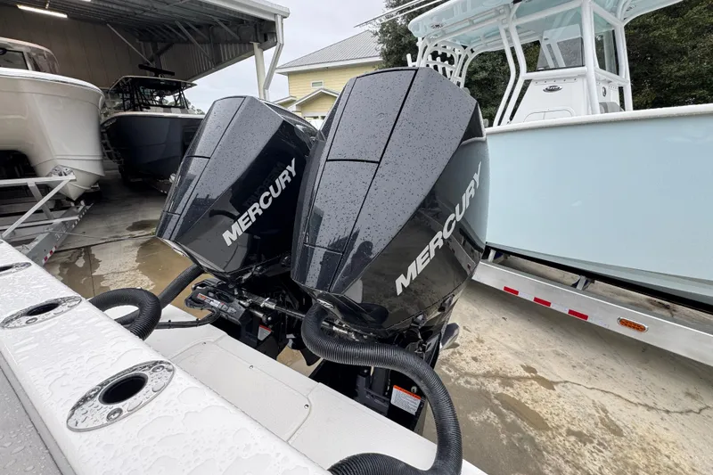 Slide: The Image of Twin Mercury outboard engines on a 2026 Sea Born LX26 Center Console boat in a marina. - 39