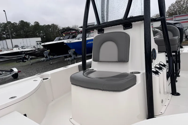Slide: The Image of 2021 Sea Born FX22 Bay boat interior with gray seating and console, parked outdoors. - 11