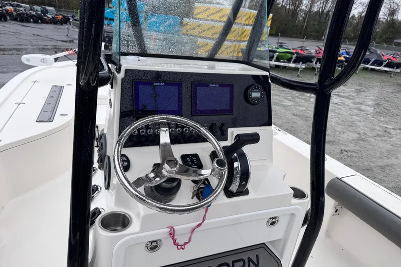 Slide: The Image of 2021 Sea Born FX22 Bay boat dashboard with steering wheel and navigation screens. - 12