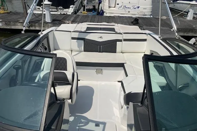 Slide: The Image of 2020 Monterey 238SS Super Sport boat interior with white and black seating at a dock. - 4