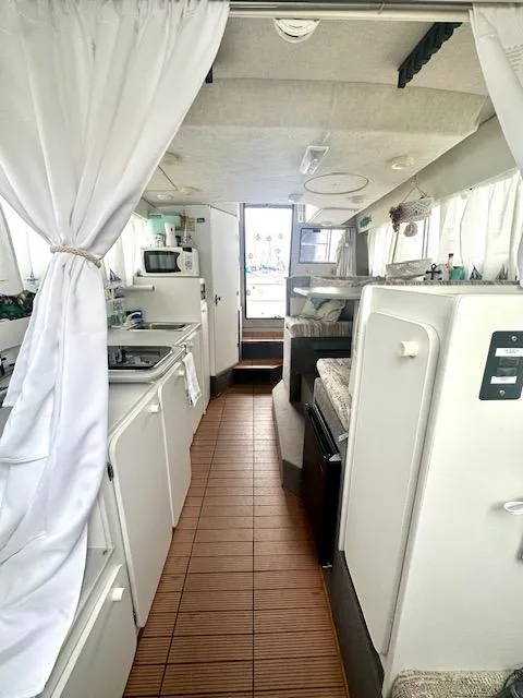 Slide: The Image of Interior of 1994 Bayliner 2858 Ciera Command Bridge, featuring kitchen and sleeping area. - 27
