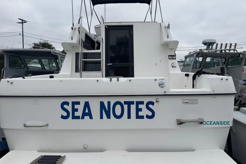 Slide: The Image of 1994 Bayliner 2858 Ciera Command Bridge named "Sea Notes" docked at a marina. - 3
