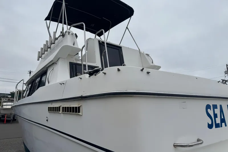 Slide: The Image of 1994 Bayliner 2858 Ciera Command Bridge boat with canopy, docked on a cloudy day. - 4