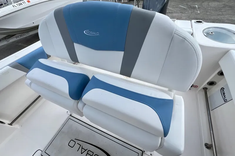 Slide: The Image of 2024 Robalo R230 Center Console boat seating with blue and white upholstery. - 16