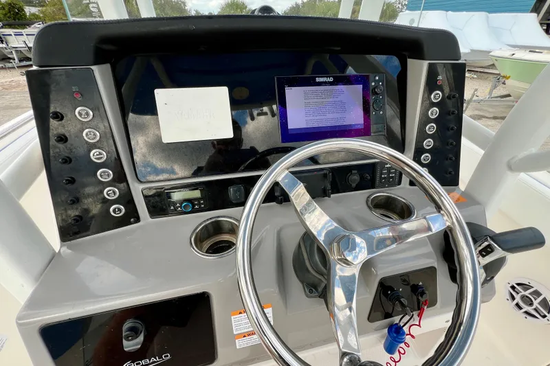 Slide: The Image of 2024 Robalo R230 Center Console dashboard with steering wheel and electronic controls. - 17