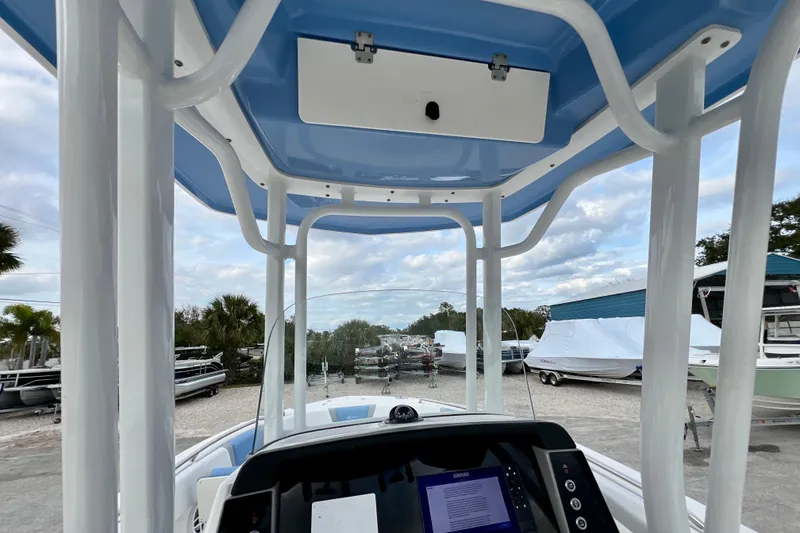 Slide: The Image of 2024 Robalo R230 Center Console boat interior with blue T-top and navigation display. - 20