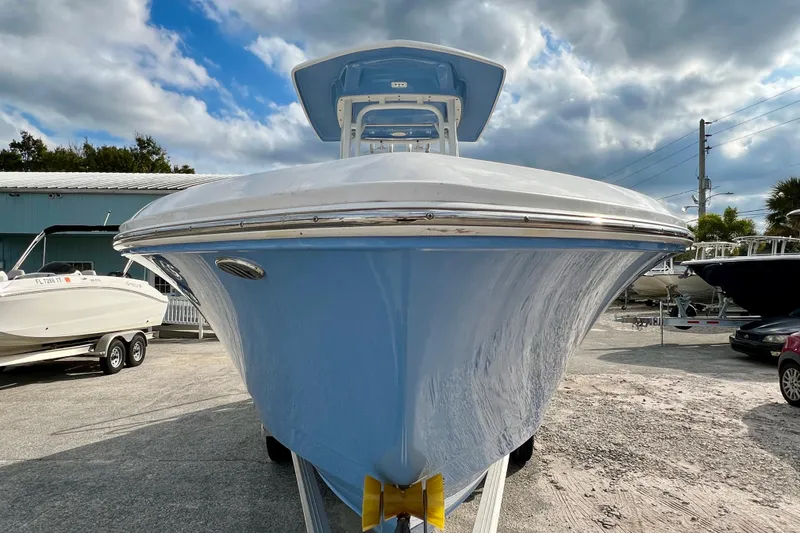 Slide: The Image of 2024 Robalo R230 Center Console boat, front view, parked outdoors under cloudy sky. - 3