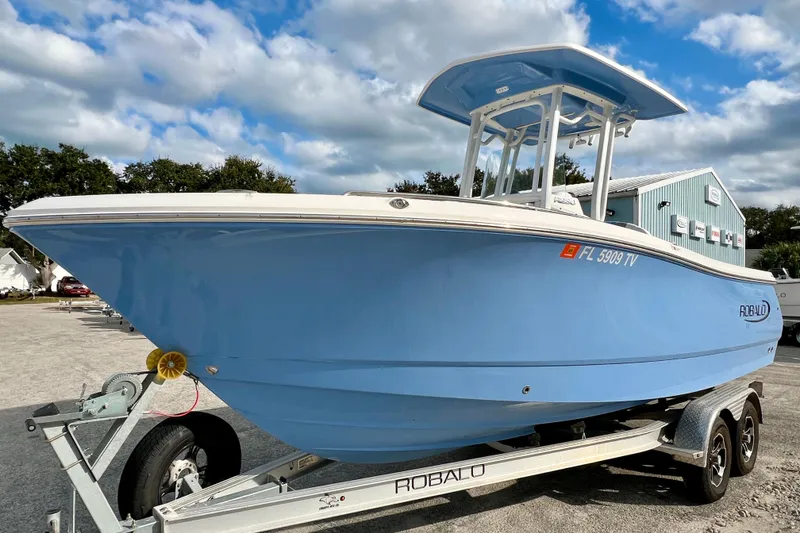 Slide: The Image of 2024 Robalo R230 Center Console boat on trailer, blue hull, outdoor setting. - 4