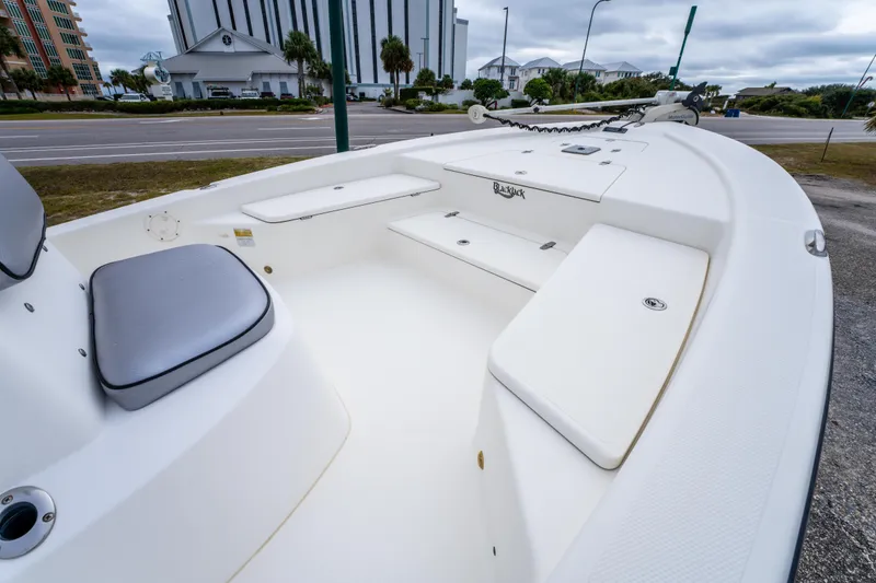 Slide: The Image of 2005 BlackJack 224 boat interior with seating and storage, parked near a road. - 11