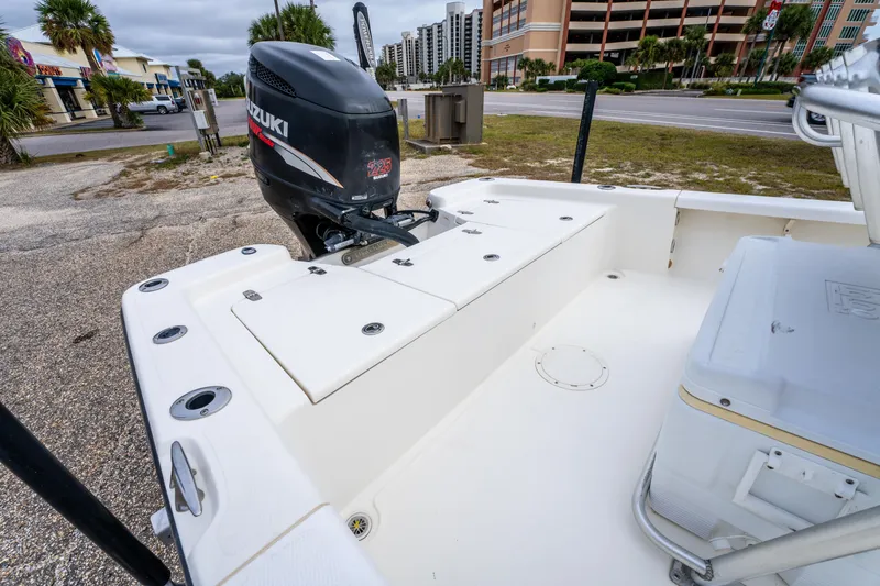 Slide: The Image of 2005 BlackJack 224 boat with Suzuki outboard motor, parked near buildings and palm trees. - 18