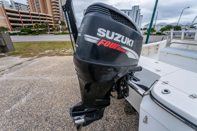Slide: The Image of Suzuki Four Stroke outboard motor on a 2005 BlackJack 224 boat, parked near buildings. - 21