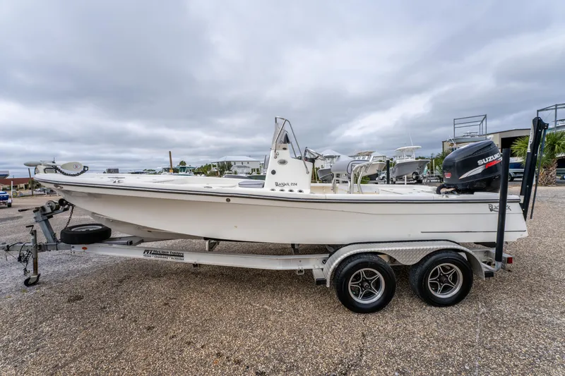 Slide: The Image of 2005 BlackJack 224 boat on trailer with Suzuki outboard motor, parked outdoors. - 5
