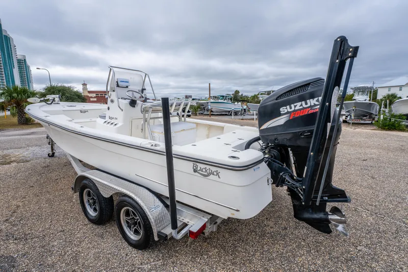 Slide: The Image of 2005 BlackJack 224 boat with Suzuki engine on a trailer, parked outdoors. - 9