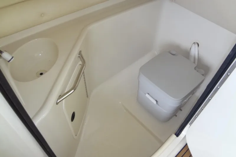 Slide: The Image of Compact bathroom in 2000 Sea Ray 240 Sundeck boat with sink and portable toilet. - 15