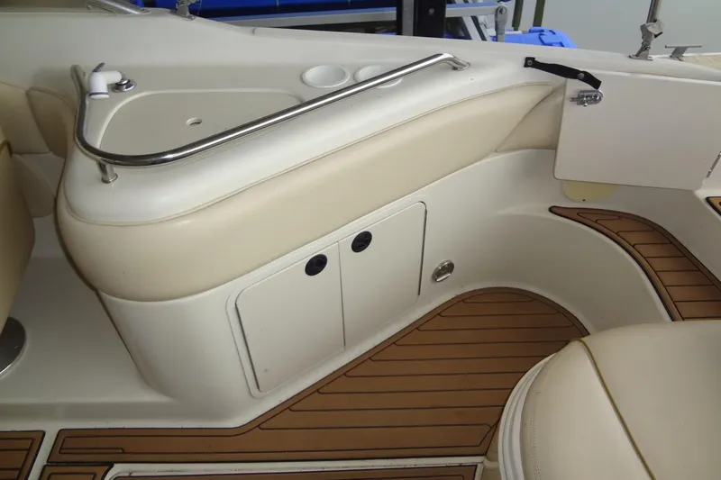 Slide: The Image of Interior of 2000 Sea Ray 240 Sundeck boat with beige seating and wood flooring. - 18