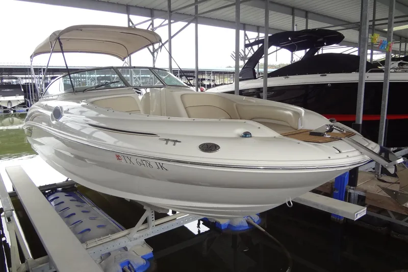 Slide: The Image of 2000 Sea Ray 240 Sundeck boat docked in a marina, featuring a beige canopy. - 3