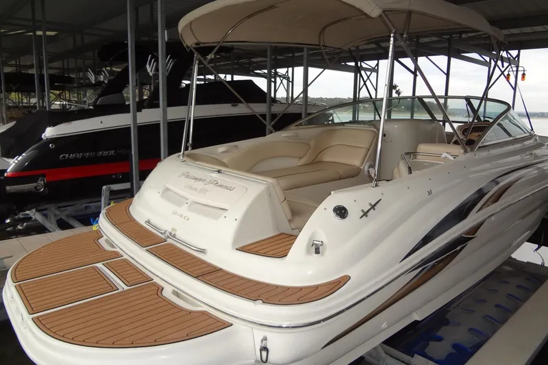Slide: The Image of 2000 Sea Ray 240 Sundeck boat with beige seating, docked in a marina. - 4