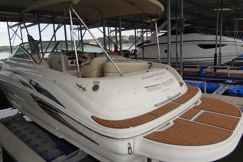 Slide: The Image of 2000 Sea Ray 240 Sundeck boat docked in marina, featuring spacious deck and canopy. - 5