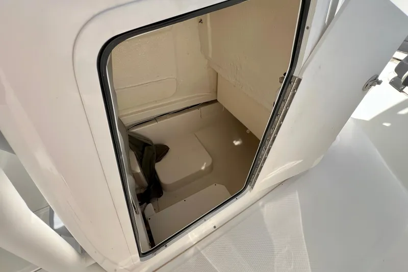 Slide: The Image of 2023 Trophy T24CC boat interior storage compartment with open door. - 18