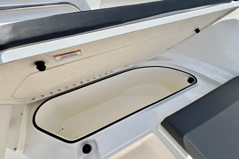 Slide: The Image of 2023 Trophy T24CC boat storage compartment with open lid and cushioned seating. - 20